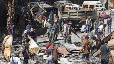 Warga bersama anggota TNI-Polri membersihkan sisa bangunan yang terbakar di Wamena/Jawa Pos
