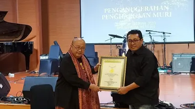 Pendiri MURI, Jaya Suprana (kiri), memberikan piagam penghargaan kepada Ketua Umum SMSI, Firdaus, di Jaya Suprana Institute, Mall Of Indonesia, Kelapa Gading, Jakarta Utara
