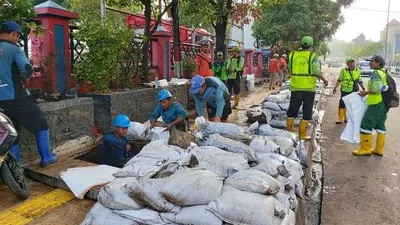 Petugas membersihkan saluran air di Jalan Tanjung Duren Raya (barat.jakarta.go.id)