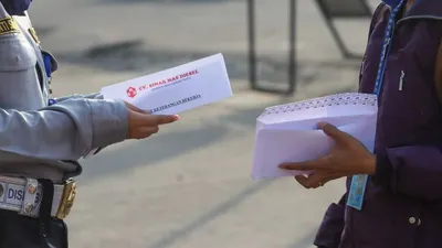 Sebagai ilustrasi, Petugas memeriksa surat tugas kantor para penumpang yang akan bekerja menggunakan transportasi Kereta Rel Listrik (KRL) di Stasiun Depok Baru, Depok, Jawa Barat, Jumat (15/5/2020). [Suara.com/Alfian Winanto]