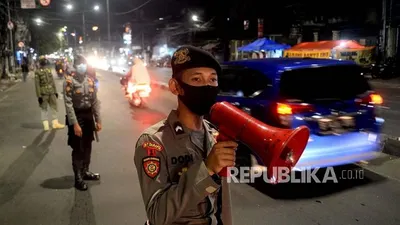 Petugas kepolisian bersama Satpol PP memberikan himbauan kepada masyarakat untuk segera pulang kerumah dan tidak melalukan konvoi atau takbir keliling  Foto: Republika/Prayogi