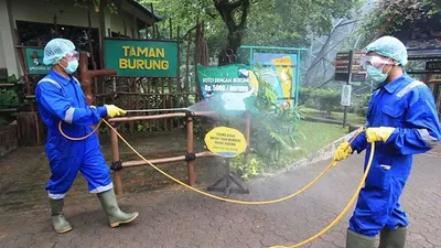Petugas menyemprotkan cairan disinfektan di Taman Burung, Taman Mini Indonesia Indah, Jakarta Timur, Rabu (18/3/2020). Taman Mini Indonesia Indah membersihkan setiap anjungan dan wahana hiburan yang ada untuk mengantisipasi wabah COVID-19. (Kontan/Baihaki)