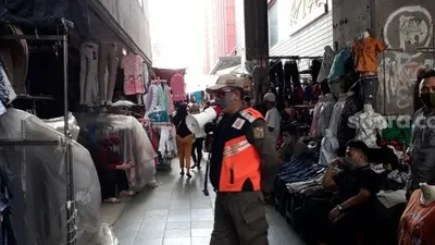 Sebagai ilustrasi: Petugas Satpol PP mengimbau warga yang ingin belanja di Pasar Tanah Abang saat PSBB untuk segera pulang. (Suara.com/Bagas)