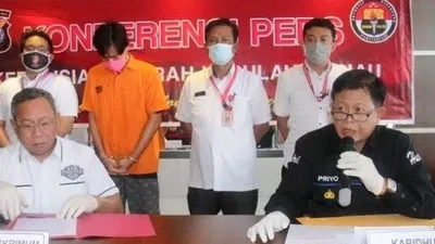 Tersangka penggelapan uang bermodus investasi bodong, V alias K, tertunduk kala dihadirkan dalam konferensi pers di Mapolda Kepri, Rabu (22/7/2020). [Foto: Batamnews.co.id]