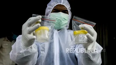 Petugas memperlihatkan wadah sampel dahak milik warga yang menjalani tes Polymerase Chain Reaction (PCR). Pemerintah Provinsi DKI Jakarta berupaya untuk meningkatkan kapasitas pemeriksaan metode RT-PCR.  Foto: Republika/Putra M. Akbar