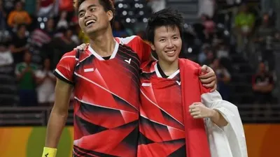 Pebulutangkis Indonesia, Tontowi Ahmad (kiri) bersama partnernya di ganda campuran, Liliyana Natsir, merayakan keberhasilan meraih medali emas di Olimpiade 2016 Rio de Janeiro. [AFP/Goh Chai Hin]