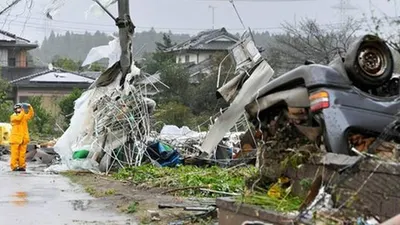 Seorang petugas berdiri di tengah puing-puing menyusul topan kuat di Ichihara, Chiba dekat Tokyo/AP