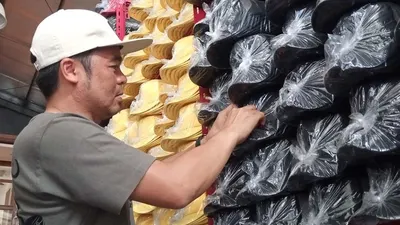 Asep Andyan, salah satu pelaku usaha UMKM Topi Desa Rahayu, menata topi hasil produksinya. (Ayobandung/Mildan Abdalloh)