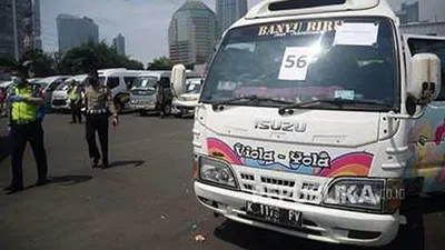 [Ilustrasi] Seorang polisi melintas di depan mobil travel gelap yang terjaring dalam operasi khusus di titik penyekatan di Polda Metro Jaya, Jakarta, Senin (11/5/2020) (Foto: Republika/Prayogi)