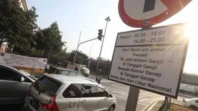 Petugas melakukan sosialisasi saat uji coba perluasan ganjil genap di kawasan Tomang, Jakarta, Senin (12/8). [Suara.com/Arya Manggala]