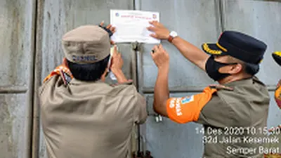 Petugas menempelkan surat tanda segel kepada salah satu tempat usaha makanan/dok: utara.jakarta.go.id