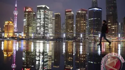 Seorang warga berjalan di depan distrik bisnis Pudong di Shanghai, China, Kamis (5/3).