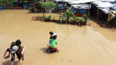 Warga menyelamatkan anggota keluarganya saat rumah mereka terendam banjir akibat luapan sungai Cisadane di kawasan Karawaci, Tangerang, Banten, Jumat (26/4/2019). Hujan deras dengan intensitas tinggi di kawasan Bogor Jawa Barat yang menyebabkan sunga Cisadane meluap hingga menyebabkan banjir di kawasan tersebut. ANTARA FOTO/Muhammad Iqbal/aww.