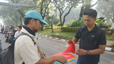 Transaksi jual beli pedagang handuk keliling di kawasan Tugu Patung Kuda Monas, Jakarta, Rabu, (26/06/2019). (Boyke Ledy Watra)