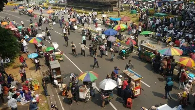 Sejumlah pedagang menggelar dagangannya di Jalan Medan Merdeka Barat ketika berjalannya aksi unjuk rasa sidang putusan Mahkamah Konstitusi, Kamis (27/6/2019). (antara/Asep Firmansyah)