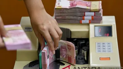 Karyawan menghitung mata uang rupiah di gerai penukaran mata uang asing di Jakarta. (ANTARA FOTO/Sigid Kurniawan)