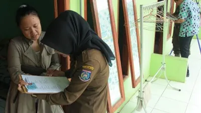Petugas Satpol PP Kota Tangerang Selatan memeriksa Kartu Tanda Penduduk (KTP) seorang warga saat Pendataan Bina Kependudukan pascalebaran di sejumlah rumah kontrakan di Ciputat, Tangerang Selatan, Banten, Kamis (20/6/2019). Kegiatan itu guna mendata para pendatang baru dan mengantisipasi masuknya pendatang gelap sebagai antisipasi terjadinya tindak kejahatan. ANTARA FOTO/Muhammad Iqbal/aww.