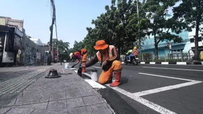 Petugas Penanganan Prasarana dan Sarana Umum (PPSU) Kelurahan Rawamangun, Kecamatan Pulo Gadung, Jakarta Timur, melakukan pengecatan kanstin di 18 ruas jalan. (Sumber: beritajakarta.id | Foto: beritajakarta.id)
