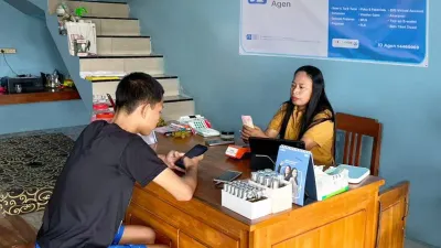 Rumiatun melayani transaksi warga di kiosnya yang kini menjadi Agen BRILink di Desa Prigi, Grobogan, mempermudah akses perbankan dan pencairan bantuan sosial.