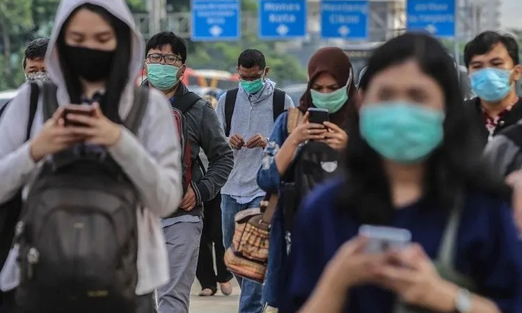 Ilustrasi - Para pekerja menerapkan protokol kesehatan dengan menggunakan masker saat berjalan di trotoar kawasan Jalan Sudirman, Jakarta Pusat. (Media Indonesia/Ramdani)