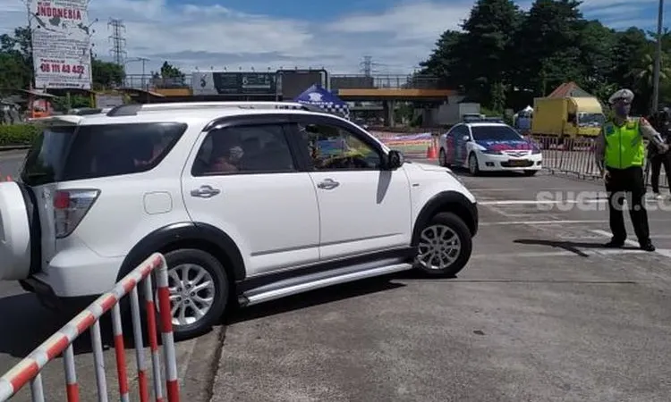 Sebuah mobil tampak tengah diputarbalik di Gerbang Tol Cikupa, Tangerang, pada H=3 Lebaran 2020 dan saat berlangsung PSBB fase ketiga [Suara.com/Stephanus Aranditio].