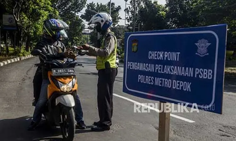Polisi memeriksa identitas pengendara motor berboncengan yang akan menuju Jalan Raya Margonda saat hari pertama pemberlakukan Pembatasan Sosial Berskala Besar (PSBB) di perbatasan Jakarta dan Depok, Lenteng Agung, Jakarta, Rabu (15/4/2020). (Foto: Republika/Putra M Akbar)