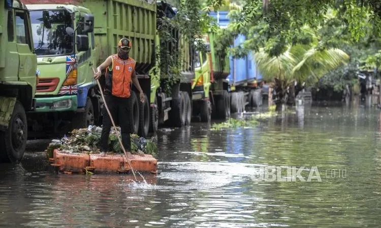 [ilustrasi] Seorang petugas membersihkan sampah dari saluran air saat terjadi banjir di kawasan Sunter, Jakarta Utara.  (Foto: Republika/Putra M. Akbar)
